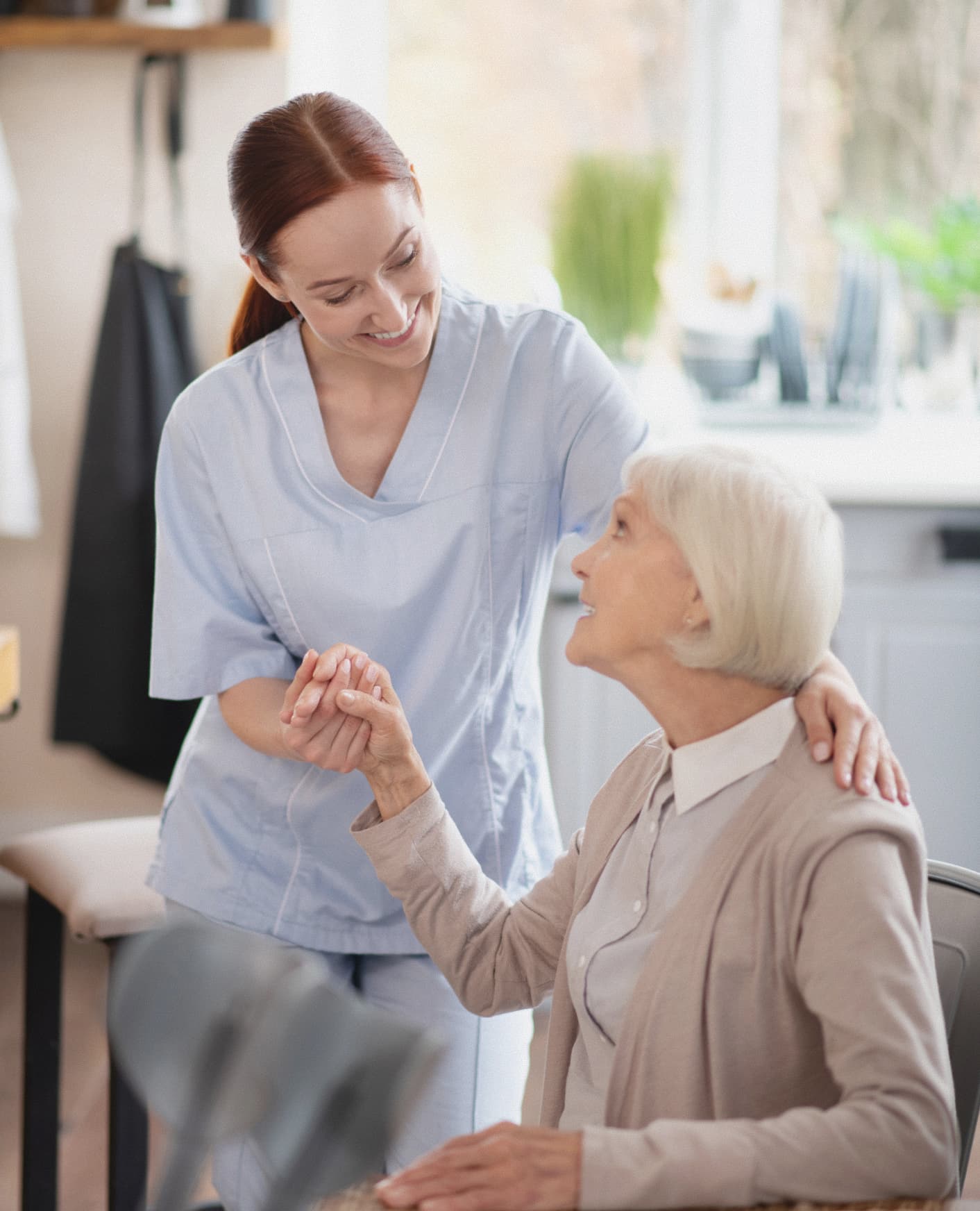 Caregiver helping senior woman at home with personal care and support