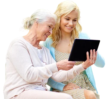A young woman and senior woman smiling together while looking at a tablet