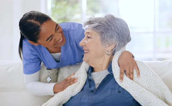 Caregiver comforting senior woman at home