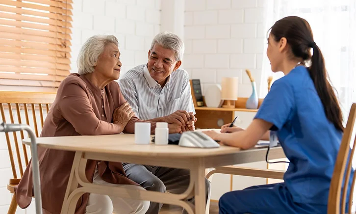 Caregiver consulting with senior couple at home