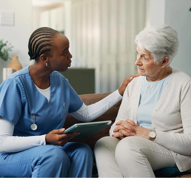 Nurse speaking with elderly woman indoors