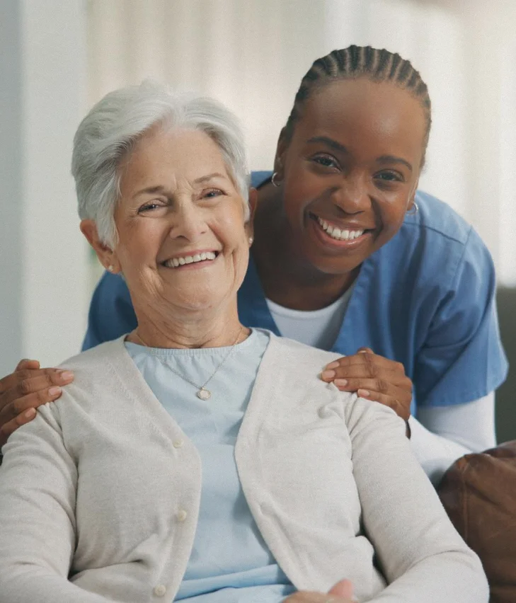Caregiver embracing smiling elderly woman