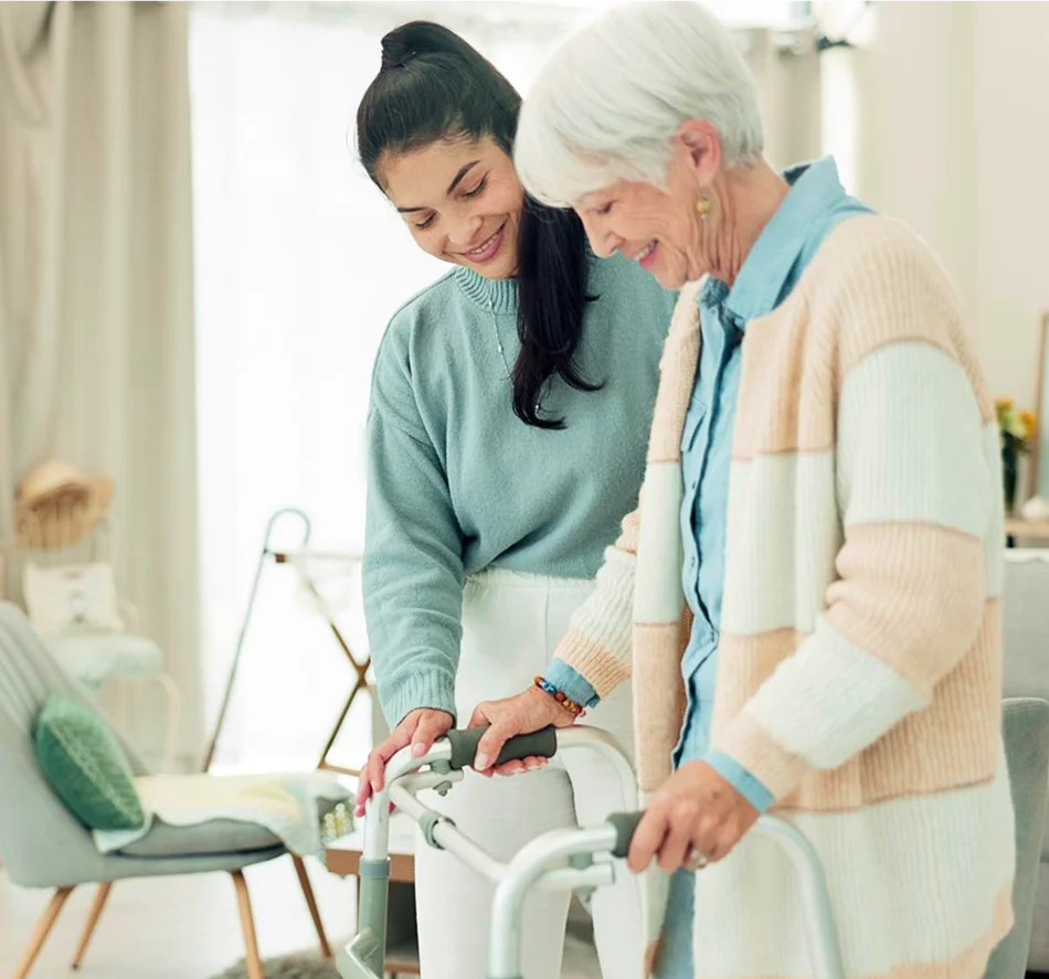 Caregiver helping elderly woman with walker