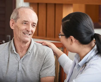 Nurse reassuring smiling middle-aged man