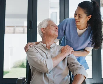 Caregiver comforting elderly man in a wheelchair
