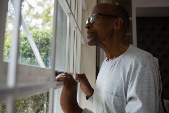 senior-man-gazing-through-window-in-quiet-thought-2026-01-11-10-31-10-utc
