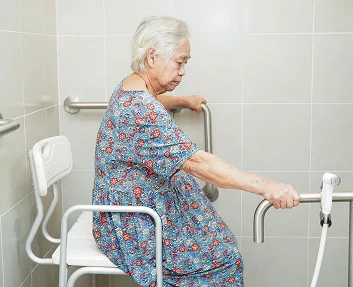 Senior woman using bathroom safety rails