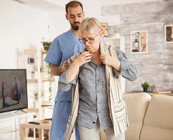 Caregiver helping senior woman walk at home