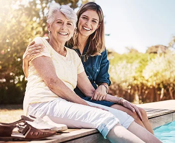 Smiling mother and daughter outdoors