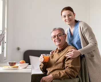 Caregiver and senior man enjoying breakfast