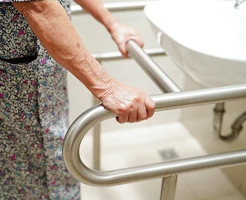Senior woman holding bathroom grab rail