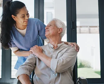 Caregiver comforting elderly man in wheelchair