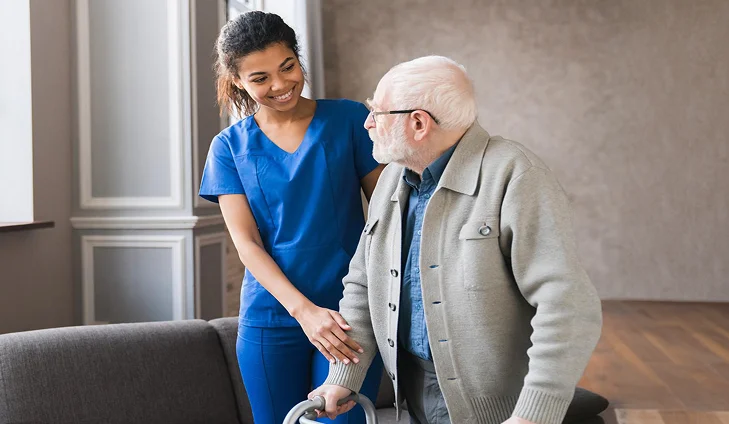 Caregiver assisting a senior man with mobility
