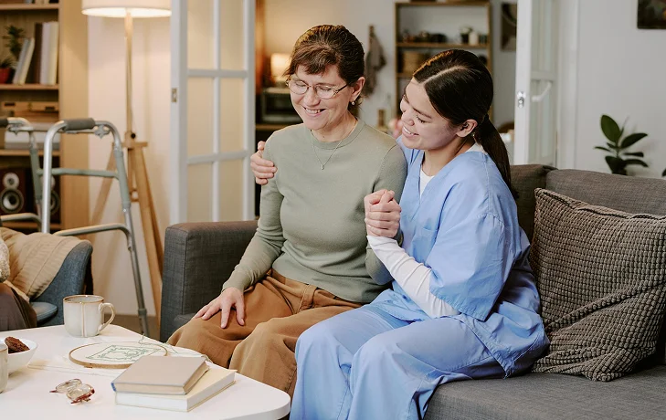 Caregiver comforting a senior woman at home