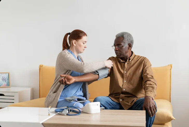 Caregiver checking a senior man's blood pressure