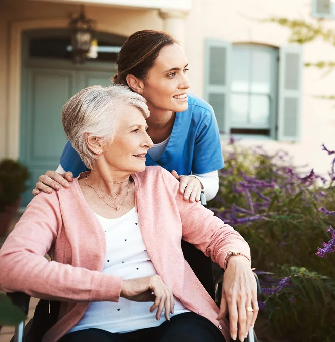 Caregiver accompanying an elderly woman outdoors