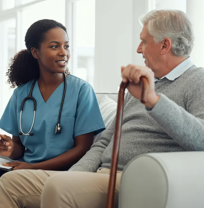 Caregiver talking with a senior man during a home visit