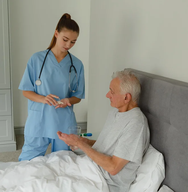 Caregiver assisting a senior man with medication