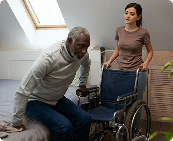 Claude responded: Caregiver helping a senior man transfer from a bed into a wheelchairCaregiver helping a senior man transfer from a bed into a wheelchair