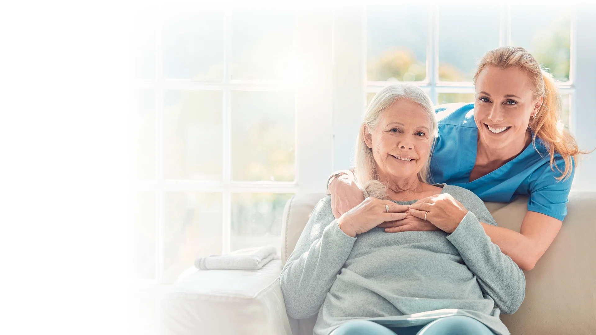 Caregiver comforting a senior woman at home