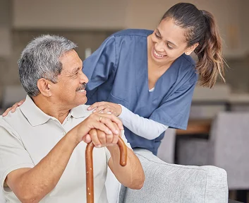 Smiling caregiver with hand on elderly man's shoulder