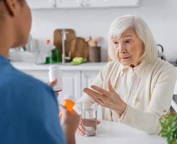 Caregiver comforting a senior woman at bedtime