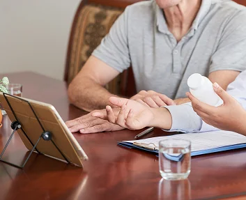 Caregiver reviewing medications with a senior patient
