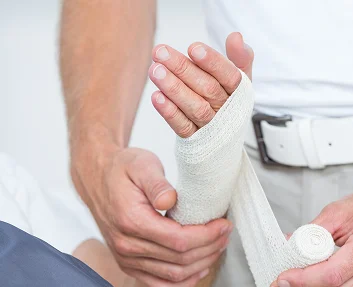 Healthcare professional bandaging a patient's hand