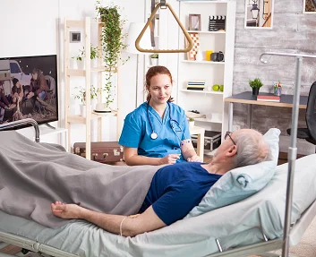 Caregiver assisting a senior woman in bed