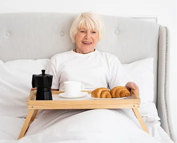 Senior woman enjoying breakfast in bed