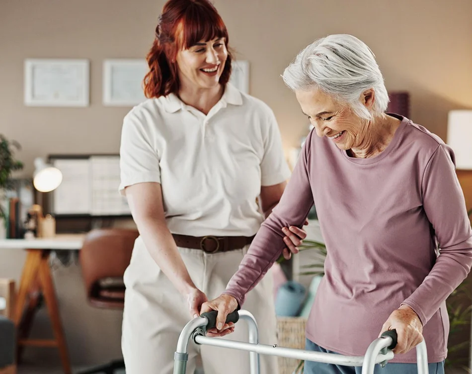 Caregiver assisting an older woman with a walker