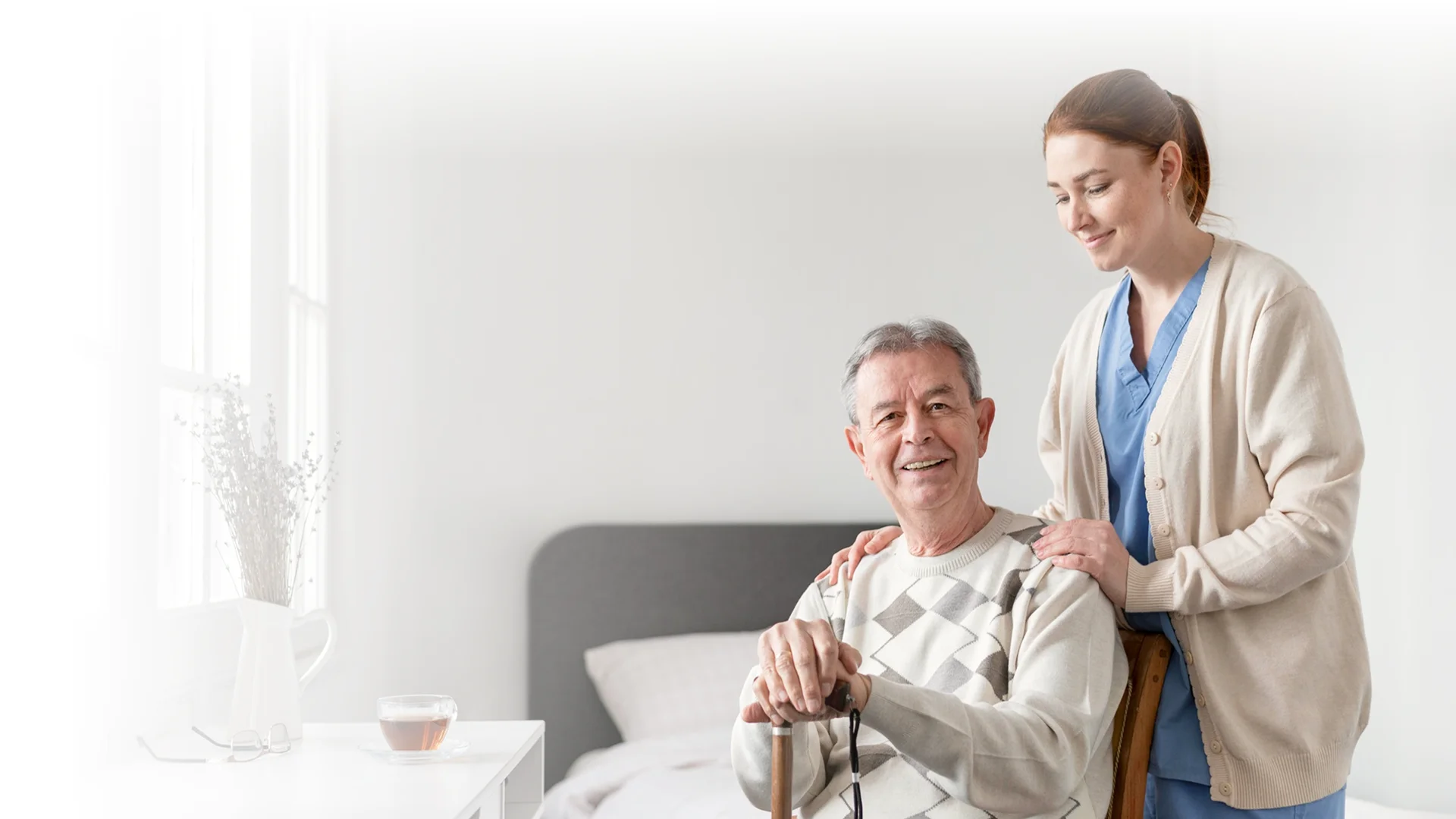 Caregiver standing beside an older man with a cane