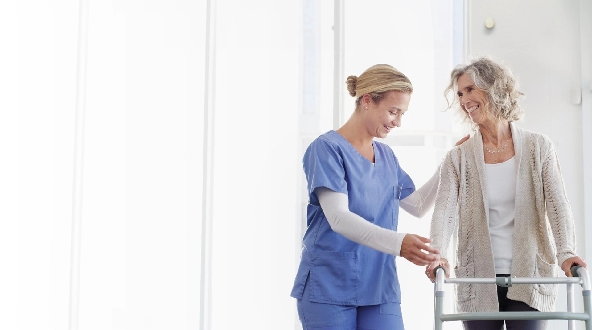 Caregiver assisting an older woman using a walker at home