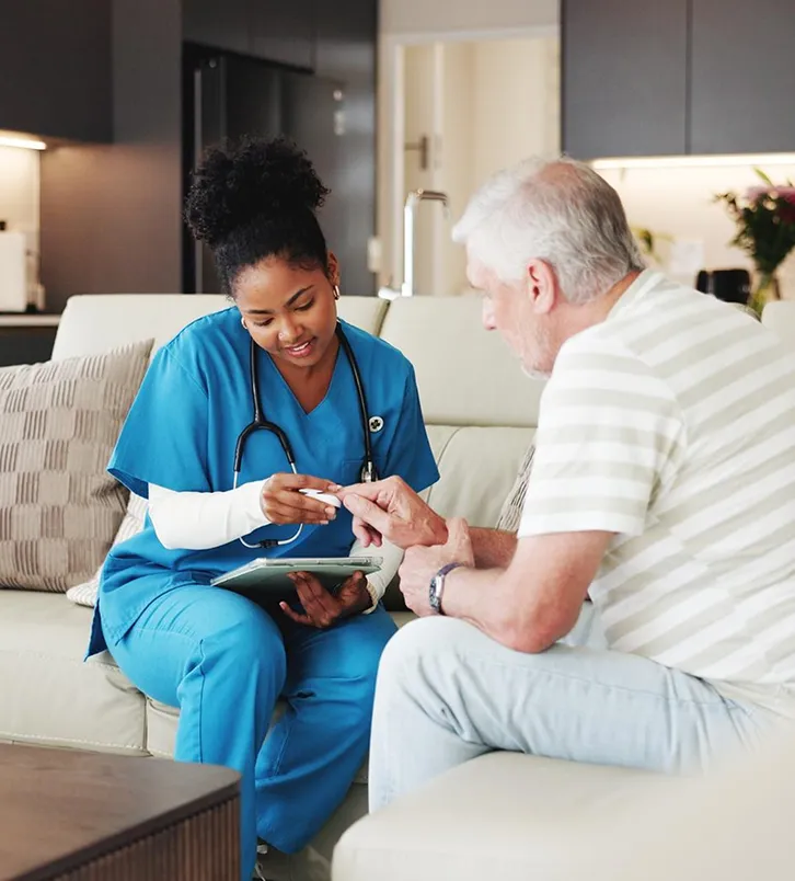 Nurse checking a senior man’s blood sugar at home