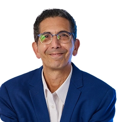 Professional man in navy blazer and glasses smiling at camera headshot